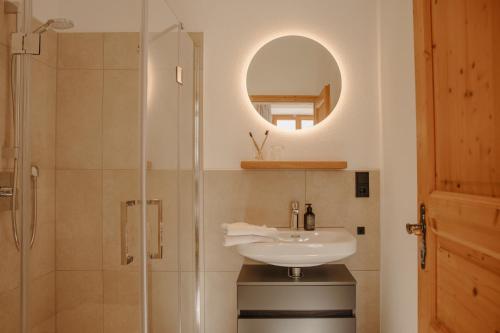 斯陶达奇格达赫Staudingerhof的浴室配有盥洗盆和带镜子的淋浴