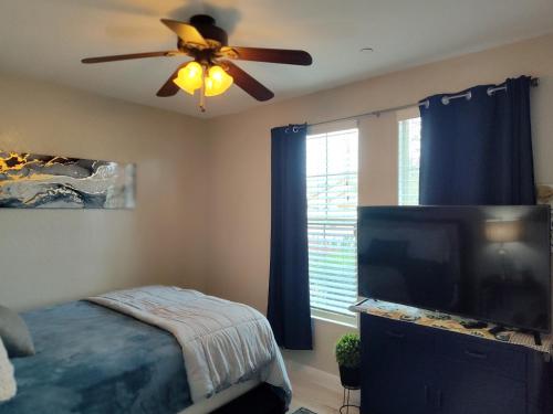 维塞利亚Buena Vista home的一间卧室配有吊扇和一台平面电视。