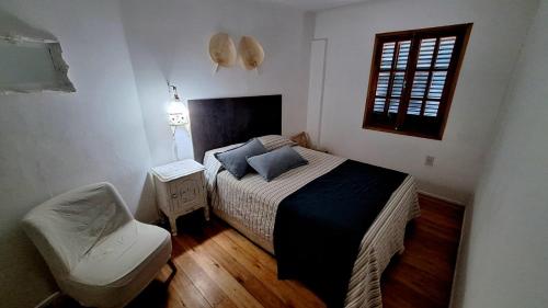 里奥夸尔托La Querencia Apart RC的卧室配有床、椅子和窗户。