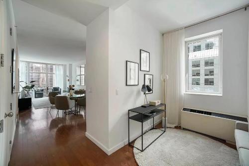 纽约FURNISHED Oversized 1 Bedroom with Home Office (Short-Term Available)的白色的客厅配有桌子和饭厅