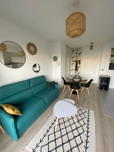 敦刻尔克Charme des quais, proche centre et plage的客厅配有绿色沙发和桌子