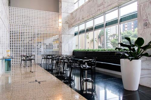 巴西利亚GS Properties - Hotel Líder的餐厅设有桌椅和大窗户。