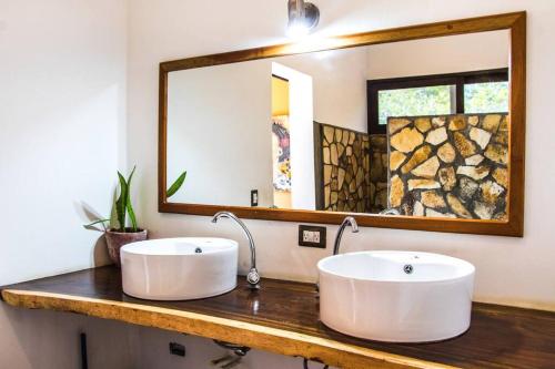 El PlantelPerfect family home in Playa Maderas的两只带镜子的柜台上的白色水槽