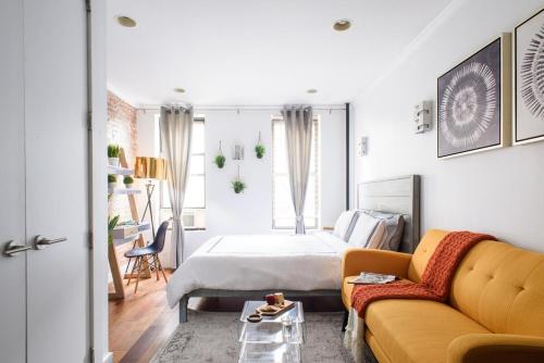 纽约24-5 Furnished Studio W D Prime Gramercy的一间卧室配有一张床和一张黄色的沙发