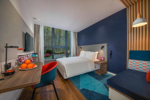 上海上海徐汇滨江智选假日酒店的酒店客房,配有一张床和一张桌子,放着一碗橘子