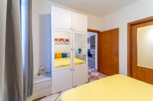 帕尔马A Casa di Luca的卧室配有白色橱柜和黄色的床