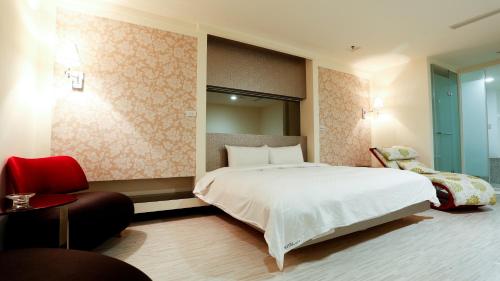 台北沃客商旅正义馆的卧室配有一张白色大床和一把椅子