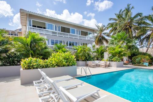 简蒂埃尔JT Curacao Apartments的一座别墅,设有游泳池和棕榈树