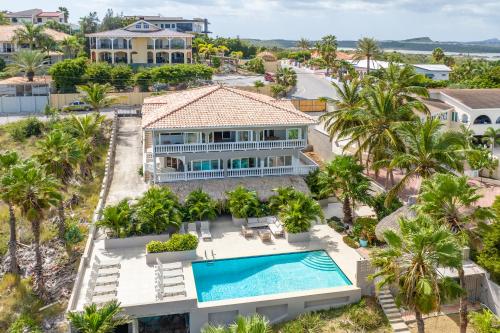 简蒂埃尔JT Curacao Apartments的享有带游泳池和棕榈树的别墅的空中景致
