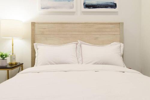 纽约69-3A Prime LES Modern Brand New 1BR的卧室配有白色的床和木制床头板