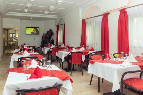 阿比让Hotel Djigui的餐厅设有红色和白色的桌椅