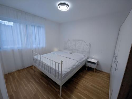 锡永A côté de l'îles Sion的卧室配有白色的床和床头柜