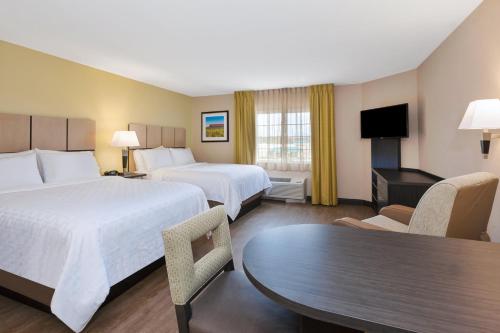落基山落基山烛木套房酒店的酒店客房设有两张床和一张桌子。