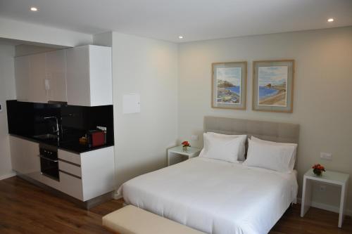 卡马拉-德洛布什Vicente´s LOB ( Lobos Ocean Breeze)的卧室配有白色的床和平面电视。