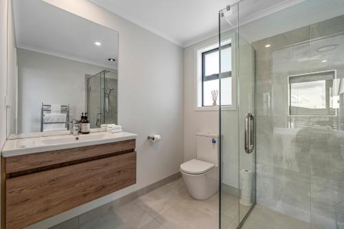 陶波Harakeke Holiday Haven - Taupo的一间带卫生间和玻璃淋浴间的浴室