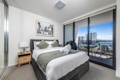 堪培拉Sensational City Apartment with Lake Views - Benjamin Way ACT的一间卧室设有一张大床和一个大窗户