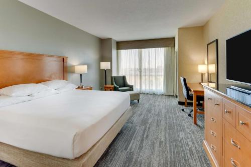 奥兰多Drury Inn & Suites Orlando near Universal Orlando Resort的配有一张床和一台平面电视的酒店客房