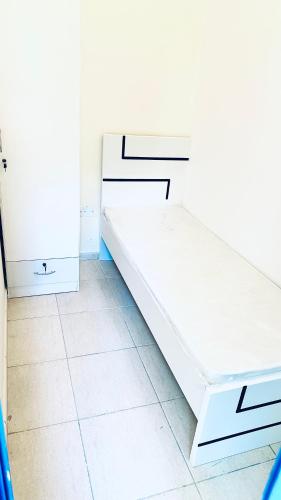 迪拜Dar Al Mansoor Vacation Homes LLC的白色卧室配有白色橱柜和瓷砖地板。