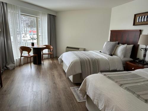 EmlentonFoxburg Inn的酒店客房设有两张床和一张桌子。