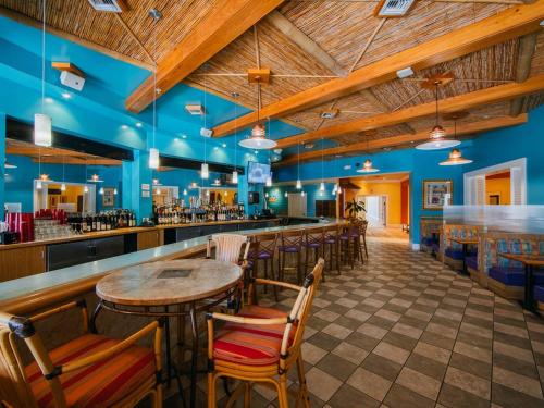 卡纳维拉尔角Holiday Inn Club Vacations Cape Canaveral Beach Resort的餐厅设有酒吧,拥有木制天花板
