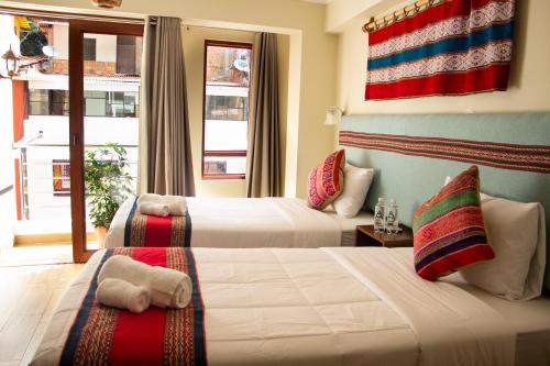 马丘比丘Rockrivers MachuPicchu的挂着一面旗帜的酒店客房内的两张床