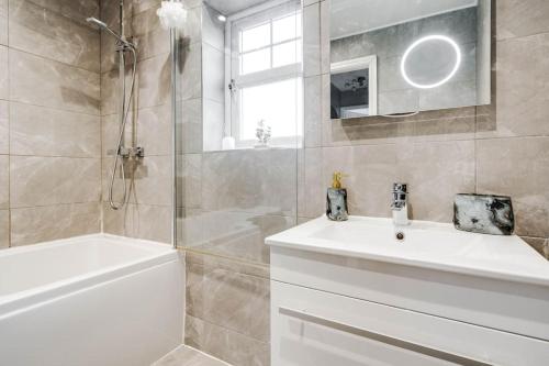 柯比Modern Warm 4 Bedroom House的浴室配有白色水槽和淋浴。