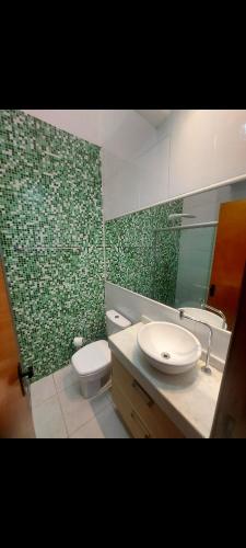 卡诺阿斯Condominio Dumont的浴室设有水槽、卫生间和绿色瓷砖。
