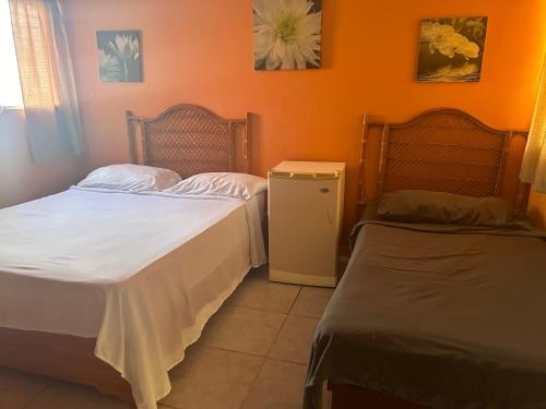 苏莎亚Coco Hotel and Hostel的橙色墙壁客房的两张床