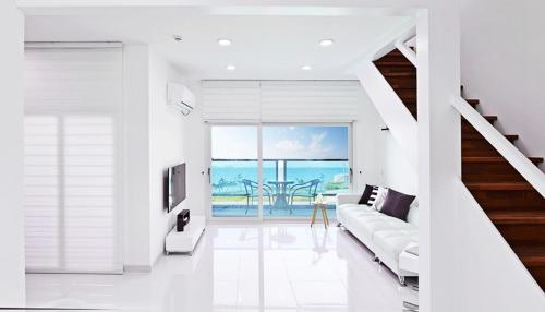 扶安Glories Pension的带沙发的白色客厅,享有海景。