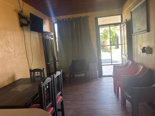 利比里亚Casa Sendero的一间带桌椅和窗户的用餐室