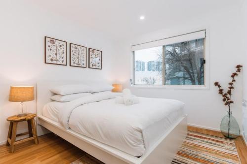 贝尔康嫩Lakeside 3-Bed Apartment with Jacuzzi的白色的卧室设有一张大床和一个窗户