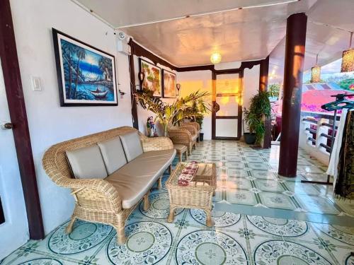 马拉帕斯加Seaside Hostel Malapascua的大堂设有藤椅和桌子,铺有瓷砖地板。