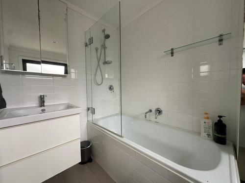 悉尼Dynamic 2 Bedroom home close to city buzz Darling St 2 E-Bikes Included的白色的浴室设有浴缸和水槽。