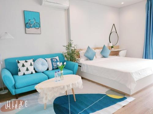 下龙湾YLY Homestay Hạ Long的一间卧室配有一张床和一张蓝色的沙发