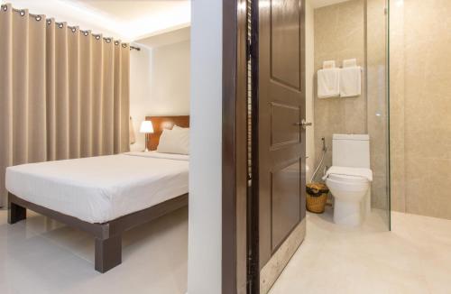 金边Cambodian Country Club的一间卧室配有一张床,浴室设有卫生间