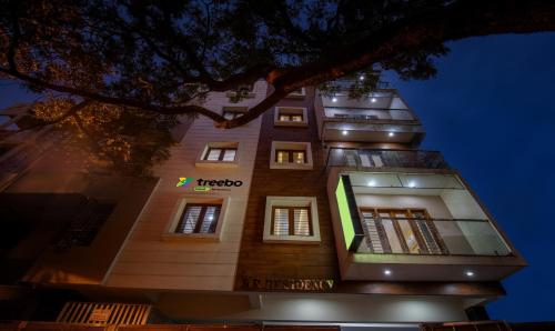 班加罗尔Treebo Trend RR Residency - Sanjay Nagar的一座高大的建筑,晚上有标志