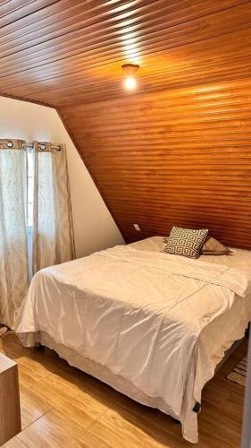 SiguatepequeCasa的一间卧室设有一张木天花板床。
