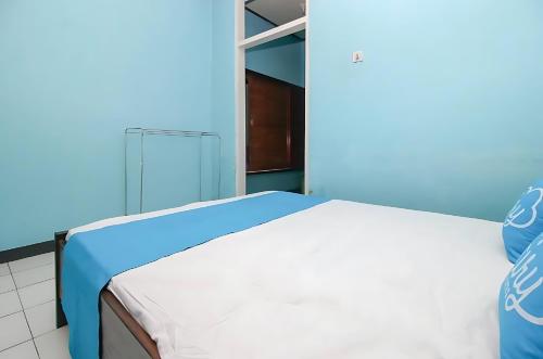 安汶Ambon Residence Syariah的蓝色墙壁间的一张床位