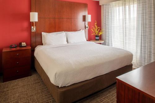 海伦娜海伦娜万豪居家酒店的一张位于酒店客房的大床,拥有红色的墙壁
