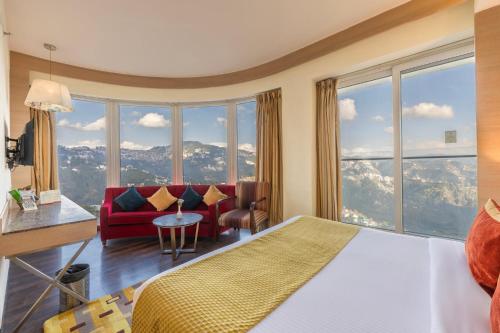 西姆拉Echor Shimla Hotel - The Zion的酒店客房设有一张床和一个大窗户