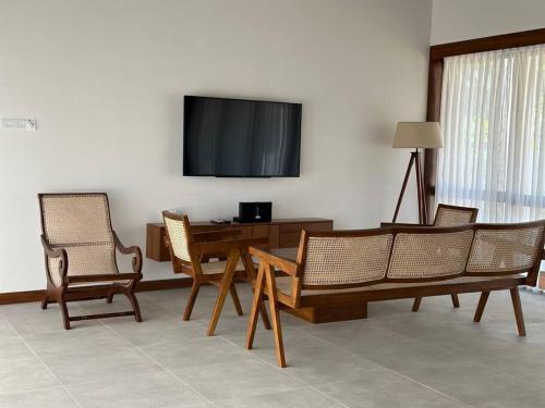 库鲁内格勒Lake Round Luxury House的客厅配有桌椅和电视。