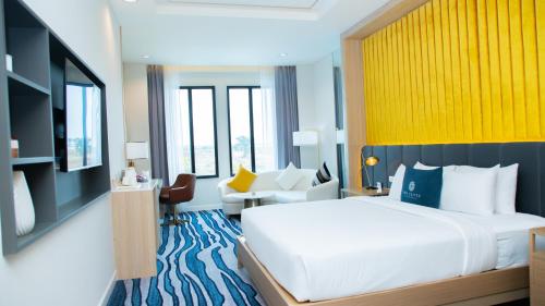 沙湾拿吉沙湾度假酒店的卧室配有一张白色大床和黄色墙壁