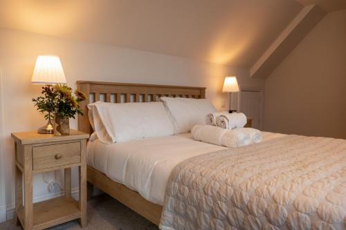 北巴拉胡利什Forest Corner Luxury Apartment with Hot Tub的一间卧室配有一张大床和一个带四柱床的床头柜。