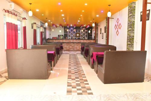 DhangadhiHotel Jiyan Hospitality Pvt. Ltd.的餐厅的一排椅子,有格子的地板