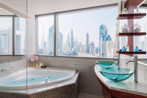迪拜Jumeirah Living World Trade Centre Dubai的带浴缸的浴室和大窗户