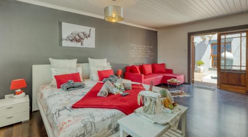 惠灵顿B&B Sauvignon Country Lodge的一间卧室配有一张带红色枕头的大床