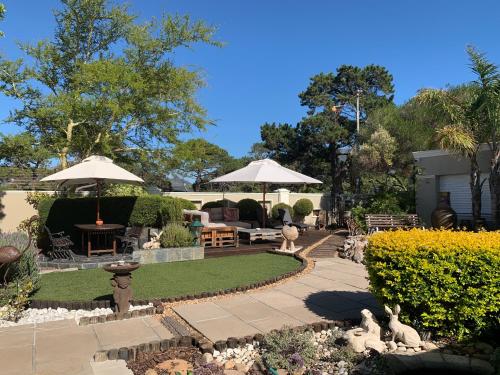 开普敦Kaya La Provence的花园设有带遮阳伞和桌椅的庭院。