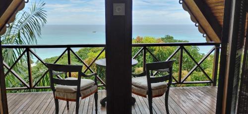 安西沃尔伯特村芒果酒店的阳台配有两把椅子,享有海景。