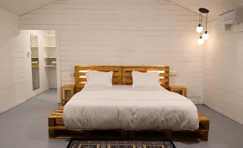 卡纳科纳The Pearl Beach Resort的一间卧室配有一张带白色床单和枕头的木制床。