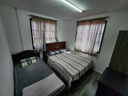 昆达桑Hillside Villa的一间小卧室,配有两张床和两个窗户